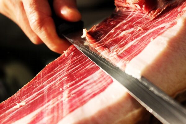 Cutting Spanish ham. Free food image, public domain CC0 photo.